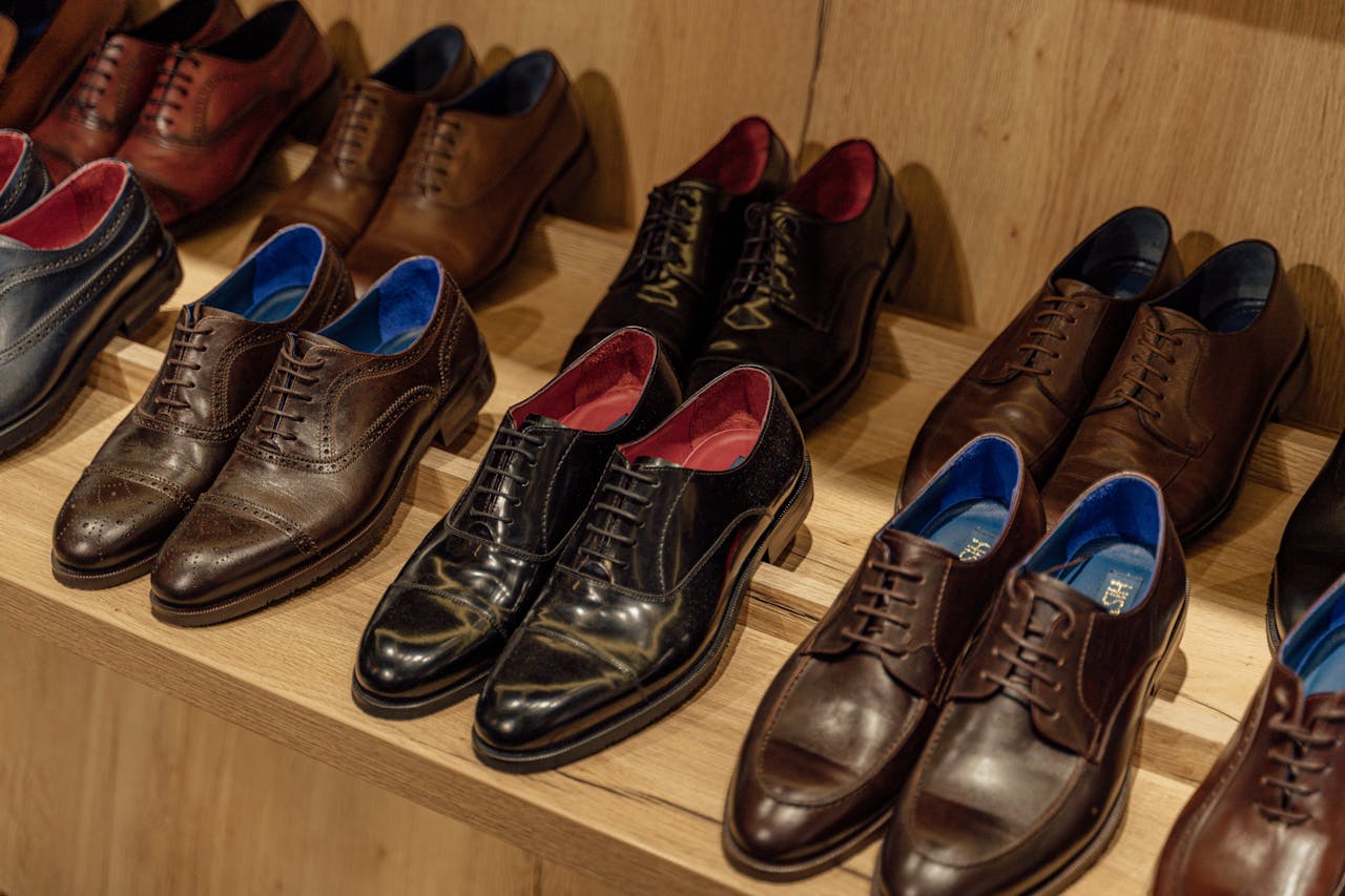 about-us Showcase of elegant leather dress shoes on wooden shelves in-store display.